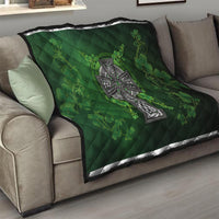 Dark green quilt on sofa with Celtic cross and shamrock floral clover pattern
