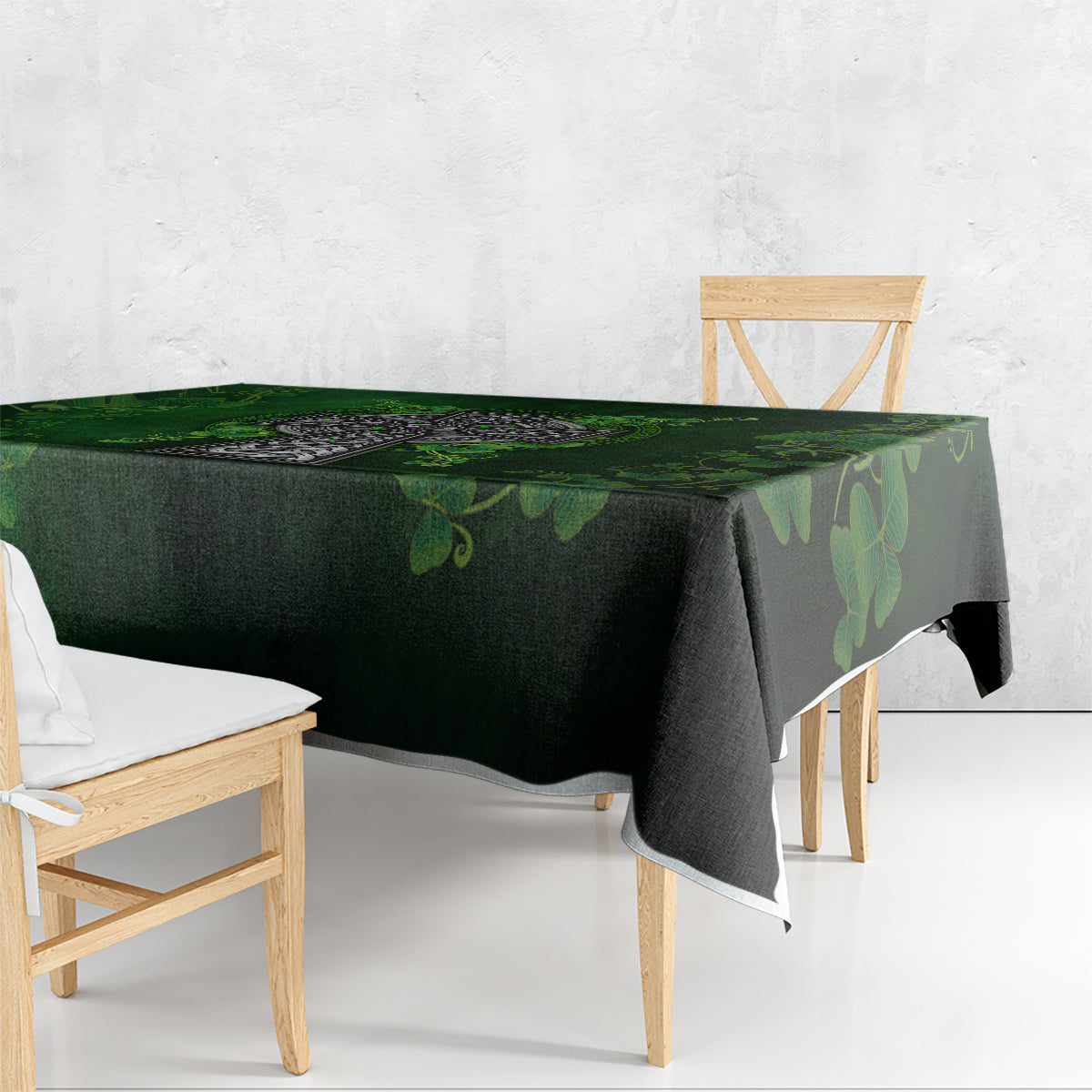 Rectangular green tablecloth with shamrock and cross design, draped over table edge.