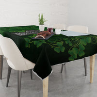 Green tablecloth with large clover leaves and Irish cross motif across table.