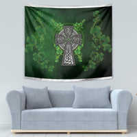 Green Irish shamrock floral tapestry with central Celtic cross emblem, hanging above sofa