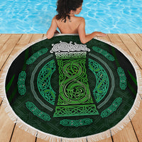 Round green-and-black beach blanket with white tassel fringe and Celtic circular design