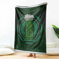 Green celtic circle design blanket with black backing, draped upright over a leg
