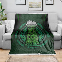 Green Celtic circle patterned blanket with tri-band border, neatly spread on a couch