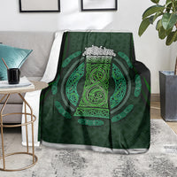 Green Celtic circle patterned blanket with ornate neon-green emblem, folded on the floor
