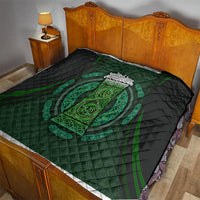 Black and green Celtic circle quilt on bed, quilted fabric with central ornate oval emblem
