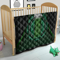 Black and green Celtic circle quilt on toddler bed, quilted texture with central ornate emblem