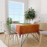 Multicolor tablecloth with green, white, and orange shamrock pattern on dining table.