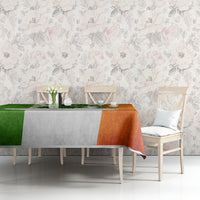 Multicolor tablecloth with green, orange, and white shamrock print on dining table.