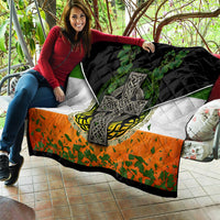 Irish cross quilt held outdoors with black, white, green shamrock and orange patterned section
