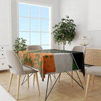 Irish-themed tablecloth with orange green shamrock print and black border on dining table.