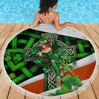 Round beach blanket showing green Irish cross clover graphic with white fringe border.