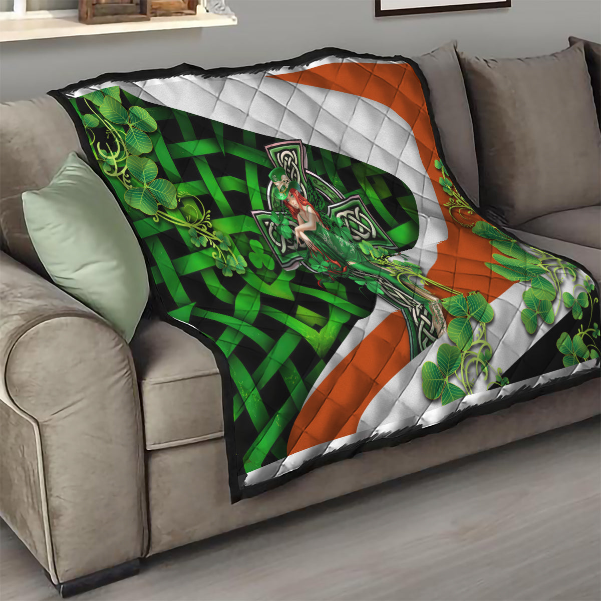 Irish-themed quilt draped on couch with central white cross, green shamrocks, and orange trim