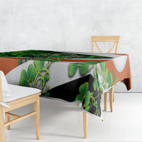 Patterned tablecloth with green leaves and Celtic knot design draping over table