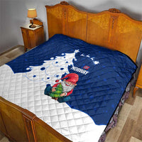 Blue and white quilt on bed with Norway lettering, gnome Santa, and Christmas tree design
