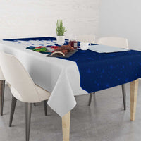 Blue holiday tablecloth draped over dining table with Norway gnome Santa artwork