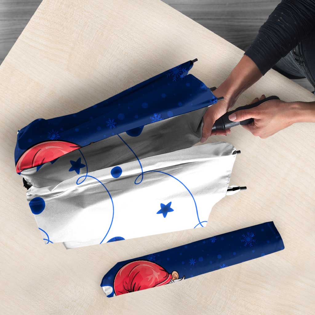 Folded blue and white umbrella with gnome Santa graphic and snowflake winter pattern
