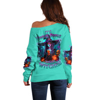 Teal off-shoulder Halloween sweater with large back witch graphic and multicolor print