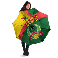 Open Guinea-Bissau umbrella with multicolor diagonal panels and star-and-laurel emblem