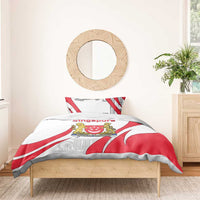 Red, white, and gray Singapore crest bedding set draped on wooden bed frame