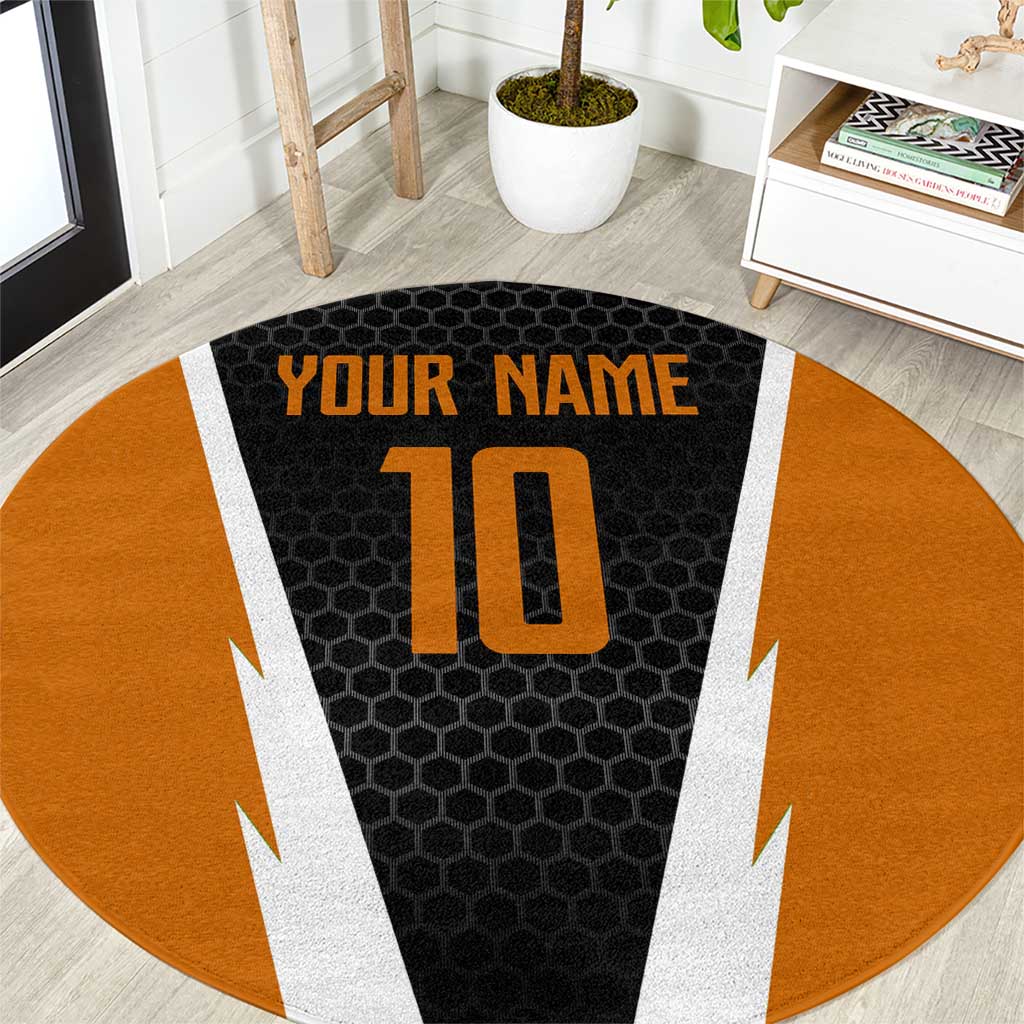Round orange and black patterned rug with white lightning accents and raised center print