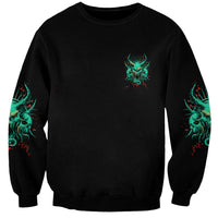 Black unisex sweatshirt with small teal skull graphic and teal sleeve accents