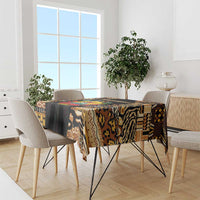 Multicolor tribal tablecloth draped over dining table, black, brown, and tan patterns