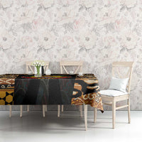 Tribal tablecloth with black and tan animal motifs and multicolor emblem on long table