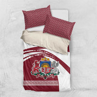 Red and white bedding set with two patterned pillows and folded duvet featuring crest and stripes