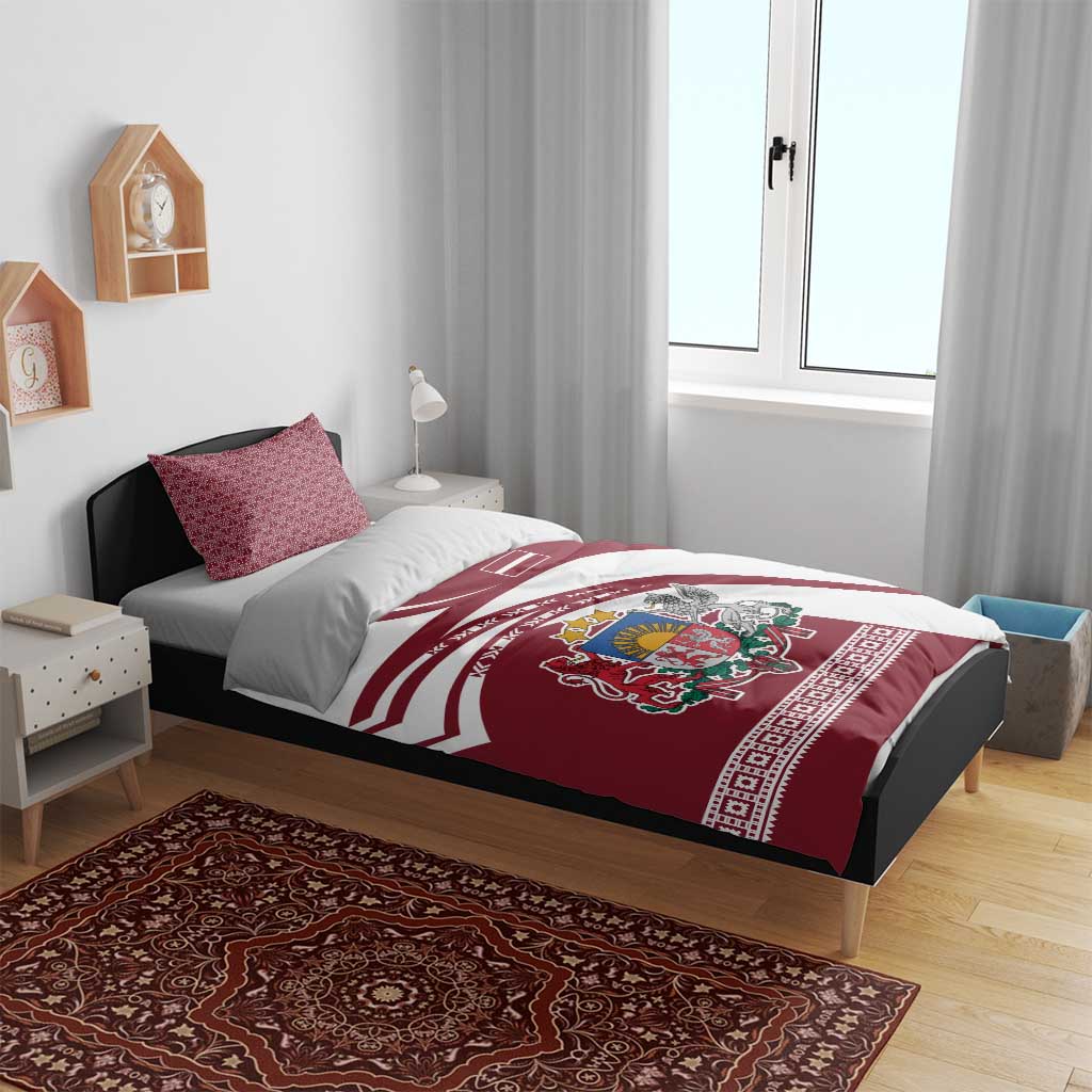 Red and white bedding set on bed with duvet showing Latvia crest and flag stripes, two pillows