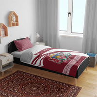 Red and white bedding set on bed with duvet showing Latvia crest and flag stripes, two pillows