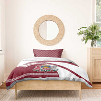 Red and white duvet and pillow set with Latvia crest, flag stripes, on wooden bed frame
