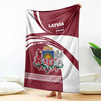 Red and white Latvia crest throw blanket with folk patterns, hanging over sofa