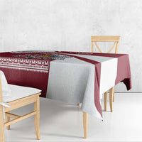 Red and white Latvia tablecloth draped over table edge with folk border trim