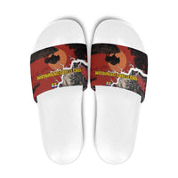 White slide sandals with red buffalo and map graphic on the strap