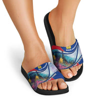 Black slide sandals with multicolor mountain graphic strap, worn with open-toe foot