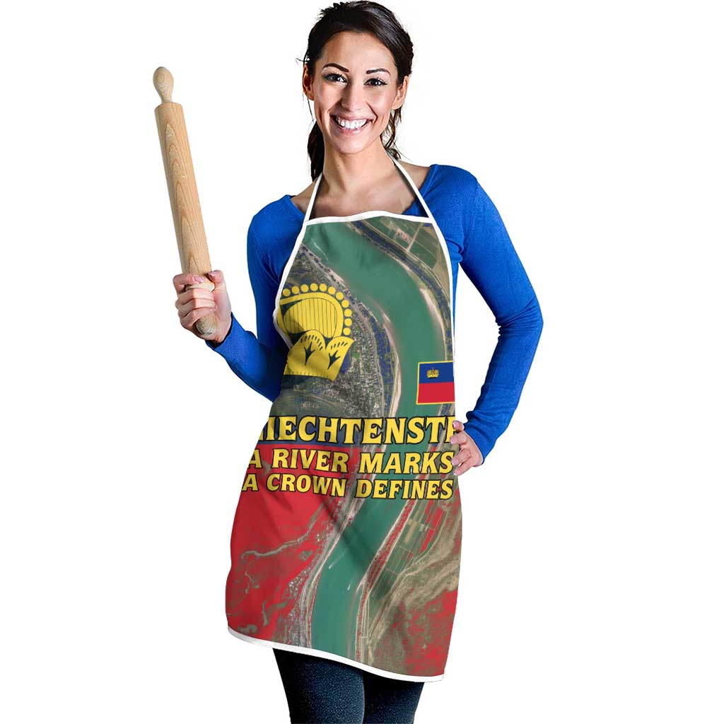 Apron with green, red, and teal river scene print, yellow crown emblem, white straps