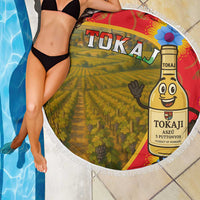 Round beach blanket draped by pool edge with Tokaj vineyard bottle design and white fringe
