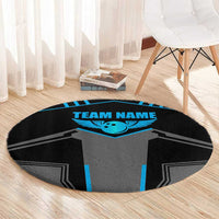 Round black rug with gray jersey artwork and blue winged emblem, labeled “TEAM NAME”.