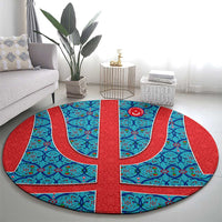 Round Turkish-style blue and red rug with central flag-style emblem and curved motifs