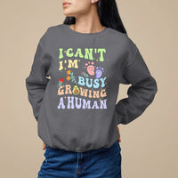 Charcoal pregnancy announcement sweatshirt with “I can't I'm busy growing a human” graphic