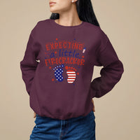 Maroon pregnancy announcement sweatshirt with expecting a little firecracker graphic and flag circles