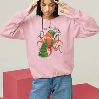 Light pink Christmas sweatshirt featuring a colorful octopus holiday graphic