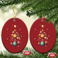 Two red oval Christmas ornaments with solar system planets and Christmas tree artwork