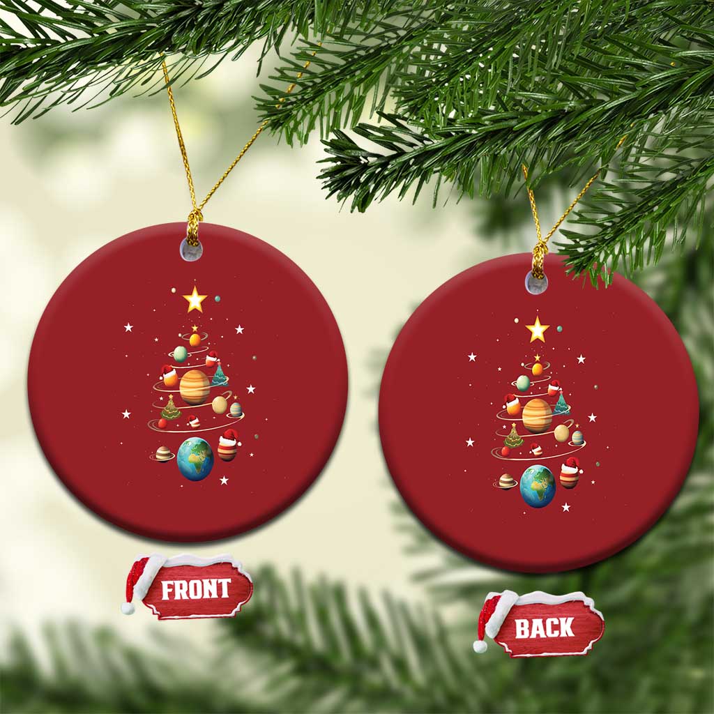 Two red round Christmas ornaments with solar system and Christmas tree artwork, hanging from strings