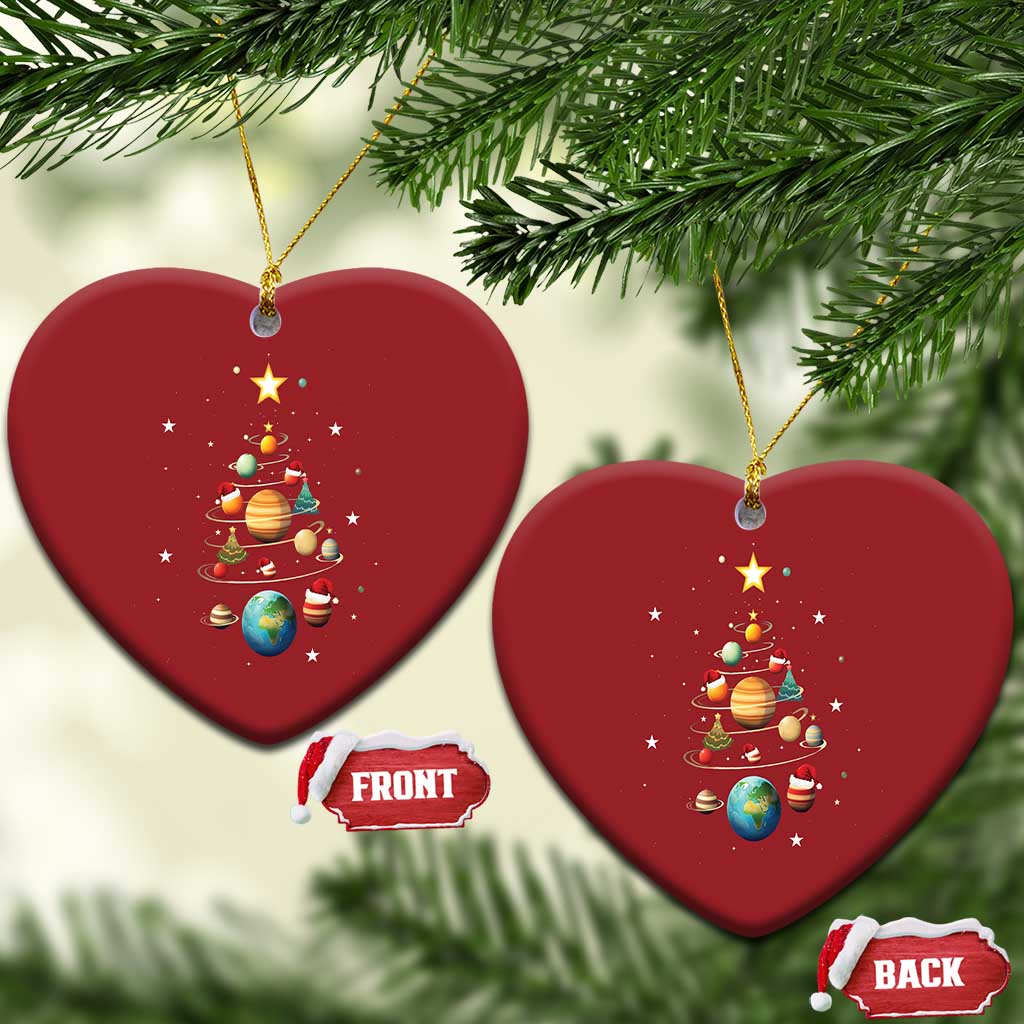 Two red heart-shaped Christmas ornaments with solar system planets and Christmas tree artwork