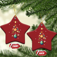 Two red star-shaped Christmas ornaments with solar system planets and Christmas tree artwork