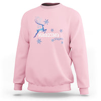 Light pink crewneck sweatshirt with blue reindeer and snowflake graphic, “Freezing Season”
