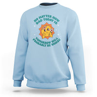 Light blue crewneck sweatshirt with cartoon heart and teal text graphic on chest