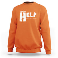 Orange sweatshirt with white “HELP” graphic and “Asking for” text on the chest
