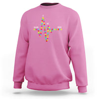 Pink crewneck sweatshirt with colorful cross-shaped text graphic on back